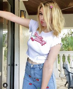 a woman with blonde hair and blue jeans is holding onto an open door that has a pink bow on it