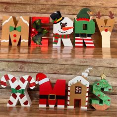 christmas decorations made out of paper are sitting on the shelf in front of a wooden wall