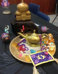 a table topped with a gold plate covered in figurines and other decorative items