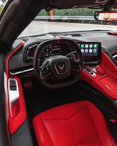 the interior of a car with red leather seats and electronic controls on the steering wheel