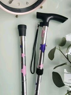 two pink and silver umbrellas next to a clock