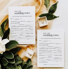 the wedding vows and rings are laid out on top of each other next to some flowers