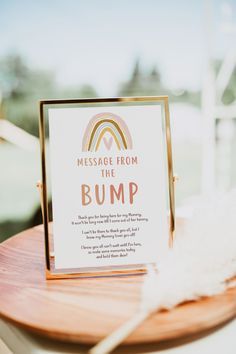 an ice cream station sign sitting on top of a wooden table next to a white feather