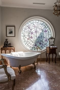 a bath tub sitting in front of a round window