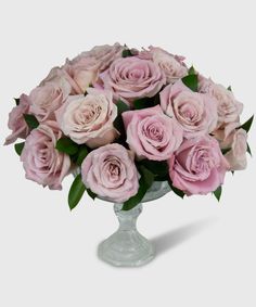 a vase filled with pink roses on top of a table