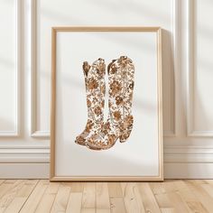 an image of a pair of boots on display in front of a white wall with wood flooring