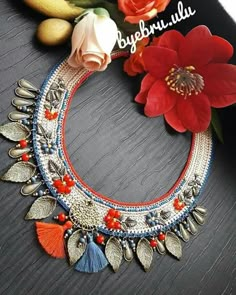 the necklace is decorated with flowers and leaves on it's side, along with other accessories