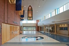 the inside of a large building with stained glass windows and an emblem on the floor