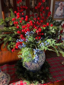 a vase filled with red and blue flowers on top of a table