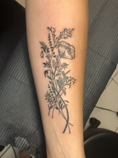 a black and white photo of a flower tattoo on the left leg, with an arrow in the center