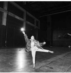 a woman is dancing on the floor with her arms in the air and one hand up