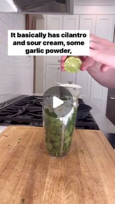 a blender filled with green vegetables on top of a wooden counter