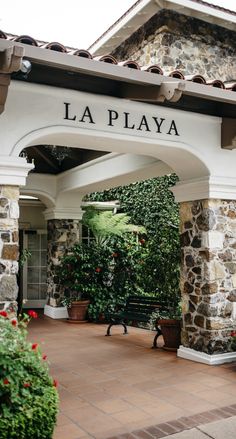 the front entrance to la playa is surrounded by greenery