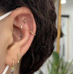 a woman's ear with three different piercings