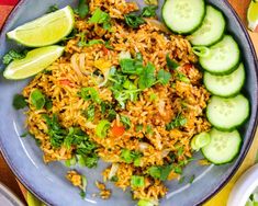 a plate filled with rice and cucumbers on top of a wooden tablecloth