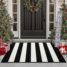 a front door decorated for christmas with wreaths and presents