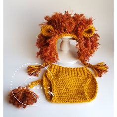 a crocheted hat, diaper cover and booties on a white background