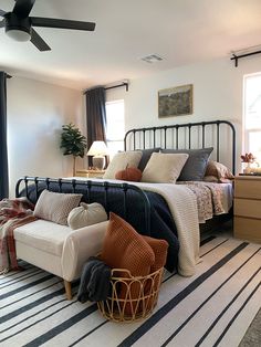 a bed room with a neatly made bed and a ceiling fan