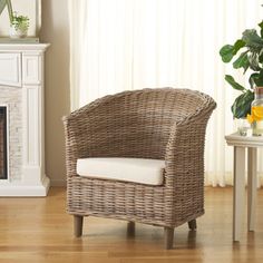 a wicker chair sitting on top of a hard wood floor next to a fire place