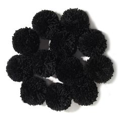 a pile of black pom - poms sitting on top of a white surface