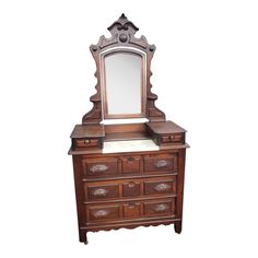 an antique wooden dresser with mirror on it's top and bottom drawer, against a white background