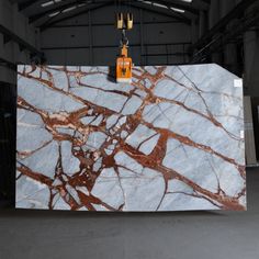 a large marble counter top in an industrial building with two orange lights hanging from the ceiling