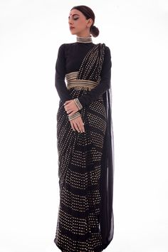 Black pre-draped saree with gold embellishments and a bandhgala blouse. Paired with hand embroidered belt.
Components:3
Embellished
Neckline:Bandhgala
Sleeve Length:Full
Fabric:Saree: Georgette, Organza; Blouse: Lycra
Color:Black, Gold
Hand embroidered belt
Cutdana and beads embellished blouse hem, neckline, sleeves hem and back zip placket
Back zip closure blouse 
Organza and georgette pallu - Aza Fashions Sarees With Belt Style, Black Organza Saree, Embellished Saree, Saree With Belt, Saree Georgette, Simple Saree Designs, Full Sleeve Blouse, Traditional Blouse Designs, Simple Sarees