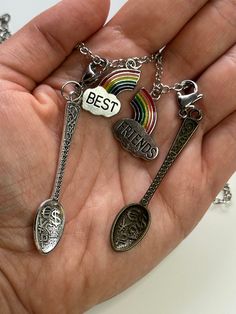 a person holding three different charms in their hand with the words best friends on them