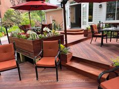 an outdoor deck with chairs, umbrellas and plants on it's side walk