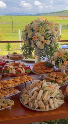 a table filled with lots of food on top of a wooden table covered in flowers