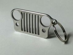 a metal keychain with a jeep grill on it's front and side