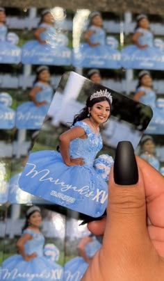 a hand holding up a card with a photo of a woman in a blue dress