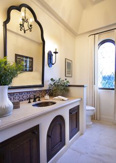 a bathroom with a sink, mirror and toilet in it's centerpieces