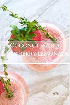 two glasses filled with strawberry lemonade sitting on top of a white marble countertop