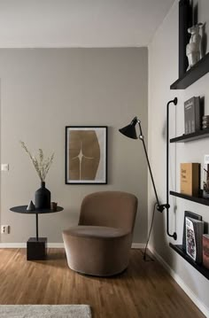 a living room with a chair, table and bookshelves on the wall in front of it