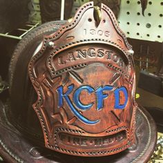 a fireman's hat with the words kcpd on it sitting on top of a chair