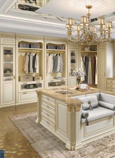 a large walk - in closet with an island and chandelier hanging from the ceiling