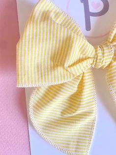 Yellow Striped Pattern  Fabric: Cotton  Sizing: - Mini: 4.5" x 4.5" - Regular: 5" x 5.5"  All items are handmade, and may contain slight variations in fabric placement. Due to different monitors and devices, colors way vary slightly. I recommend only baby or mini on nylon WARNING:  CHOKING HAZARD - Small parts Clips are not intended for children under 3 years old. It is recommended that all products should be used with adult supervision. White Bow Tie Hair Accessories For Summer, Playful Bow Headband Hair Accessory, Summer Decorative Bow Headband, Summer Bow Headband, Cute Pink Summer Bow, Playful Adjustable Bow For Summer, Adjustable Playful Bow For Summer, Cute Cotton Hair Accessories For Summer, Cute Cotton Summer Hair Accessories