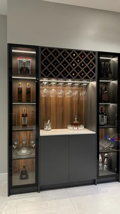 a wine cellar with many bottles and glasses in it's display case, as well as several empty glassware