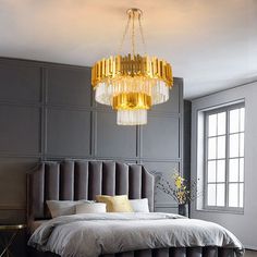 a bedroom with a large bed and chandelier hanging from the ceiling