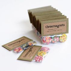 there are several tags on the table with flowers in them, and one has a tag that says threemagnets