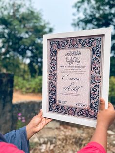 a person holding up a framed certificate in their hand