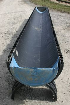 a large metal object sitting on top of a gravel road