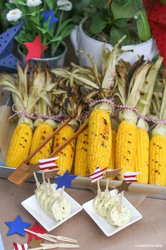 corn on the cob with toothpicks and american flag decorations in front of them