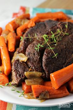 a white plate topped with meat and carrots