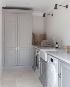 a laundry room with washer and dryer in the middle, cabinets on both sides