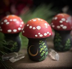 three painted mushrooms sitting on top of a wooden table