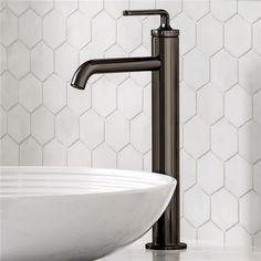 a bathroom sink with a black faucet and white bowl