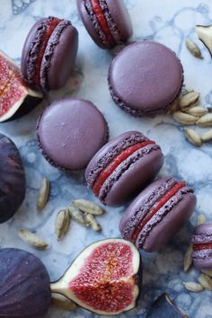 purple macaroons and other pastries on a marble surface with sunflower seeds