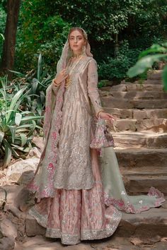 a woman in a wedding outfit standing on some steps